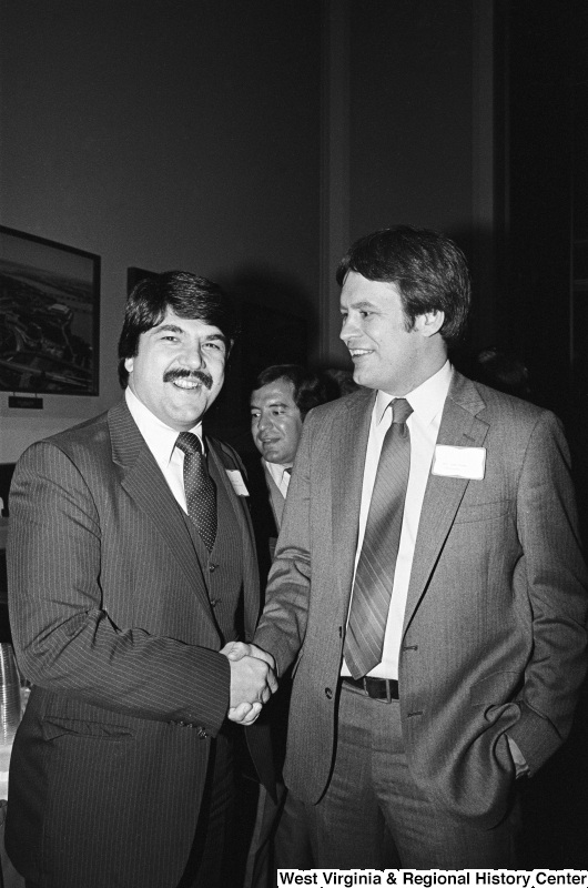 Photograph of Congressman Lane Evans (IL) and Richard Trumka at an event. Representative Nick Rahall is pictured behind them.