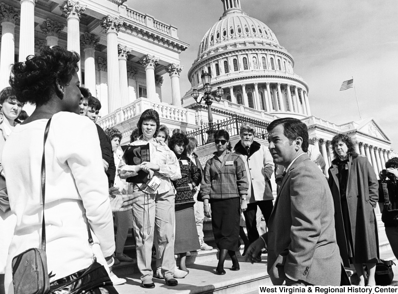 Photograph of Representative Nick Rahall on the steps of the Capitol Building with a group of unidentified people