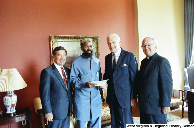 Photograph of Congressman Nick Rahall with Speaker of the House Tom Foley (WA), and House Chaplain David James Ford with an unidentified man