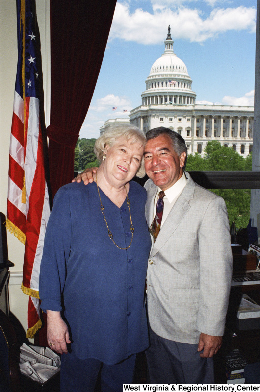 Photograph of Congressman Nick Rahall posing in his office with an unidentified woman