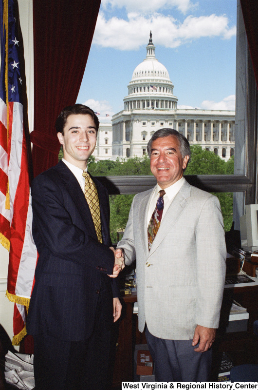 Photograph of an unidentified man posing with Congressman Nick Rahall in his office