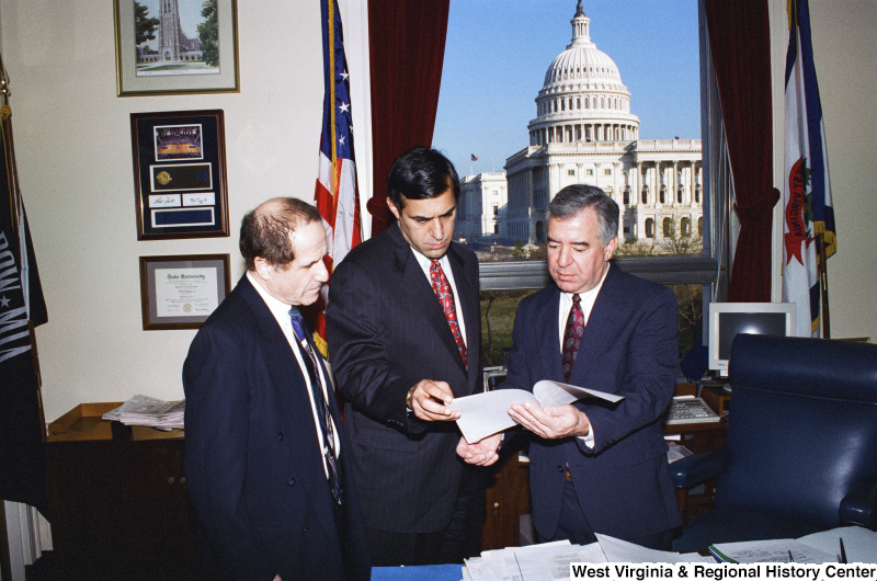 Photograph of Congressman Nick Rahall and two unidentified men looking over documents