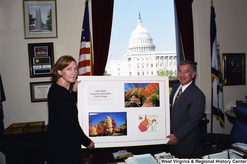 Photograph of Congressman Nick Rahall with an unidentified woman holding a poster about West Virginia fall foliage