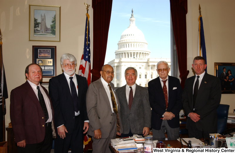 Congressman Rahall stands with five unidentified men in his Washington office.