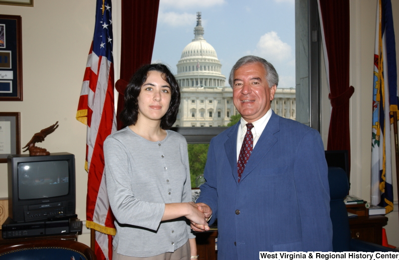 Congressman Rahall stands with a woman wearing a grey shirt in his Washington office.