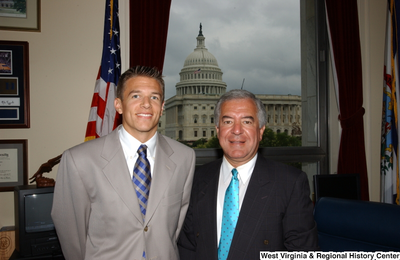 Congressman Rahall stands with a man wearing a grey suit in his Washington office.