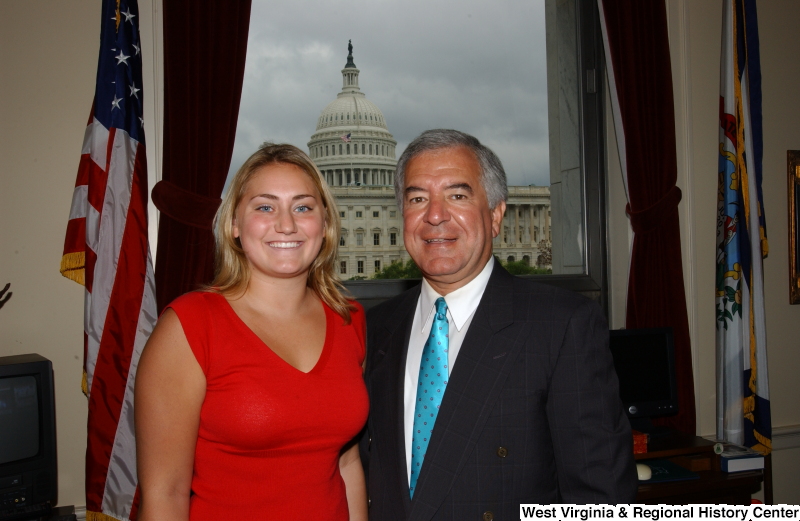 Congressman Rahall stands with a woman wearing a red shirt in his Washington office.