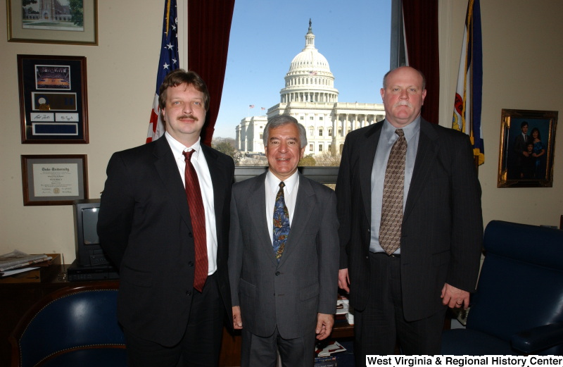 Congressman Rahall stands in his Washington office with two men.