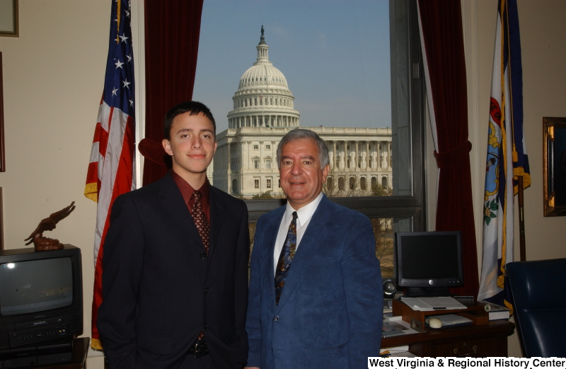 Congressman Rahall stands in his Washington office with a man wearing a dark suit and burgundy shirt.