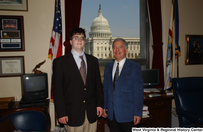 Congressman Rahall stands in his Washington office with a man wearing a dark blazer and khaki pants.