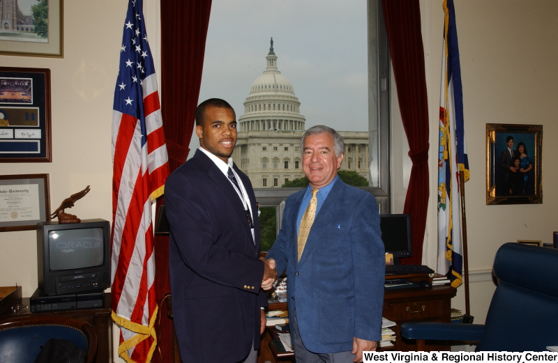 Congressman Rahall stands in his Washington office with a man wearing a dark blue blazer.