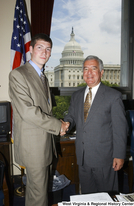 Congressman Rahall stands in his Washington office with a man wearing a taupe suit and blue shirt.