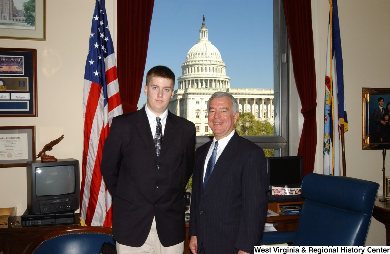 Congressman Rahall stands in his Washington office with a man wearing a dark blazer and tan pants.