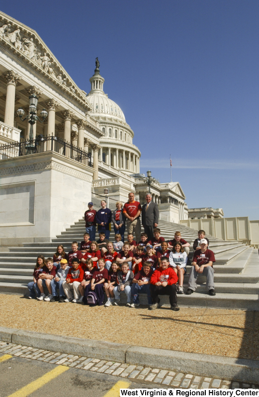 Congressman Rahall stands on the steps of the Capitol Building with children and some adults wearing "Alderson" shirts.