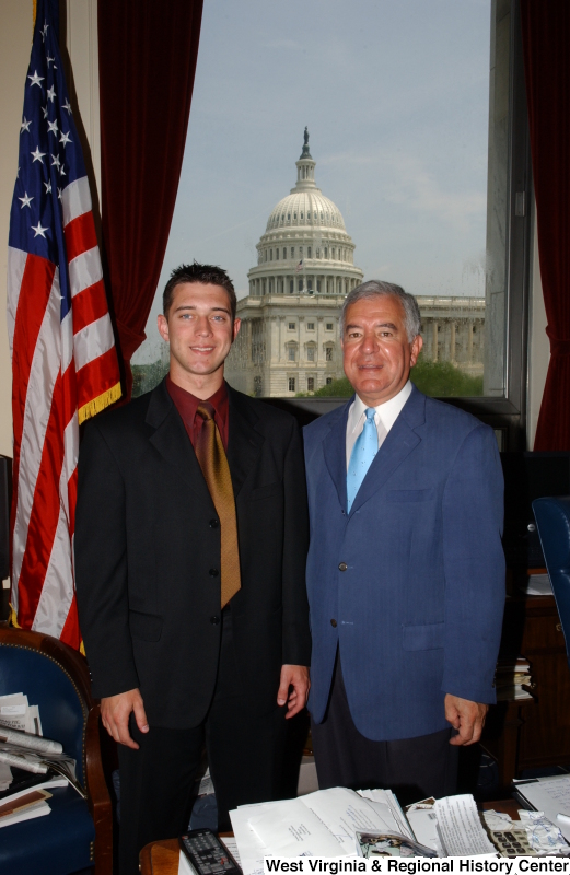 Congressman Rahall stands in his Washington office with a man wearing a dark suit, bronze tie, and burgundy shirt.