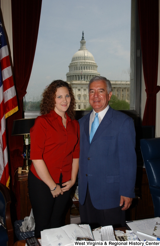 Congressman Rahall stands in his Washington office with a woman wearing a red shirt.