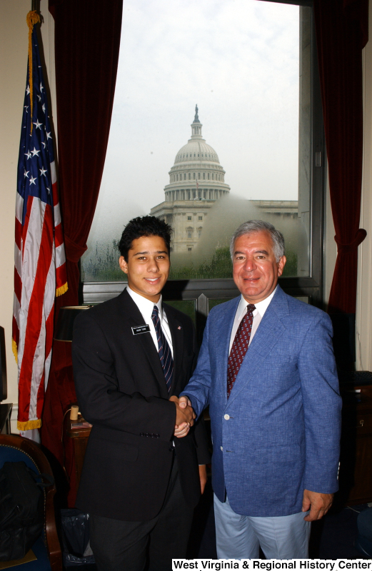 Congressman Rahall stands in his Washington office with a man wearing a name badge indicating the first name Adam.