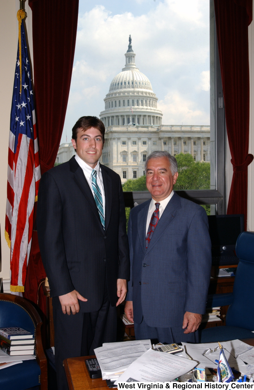 Congressman Rahall stands in his Washington office with a man wearing a pinstripe suit and turquoise striped tie.