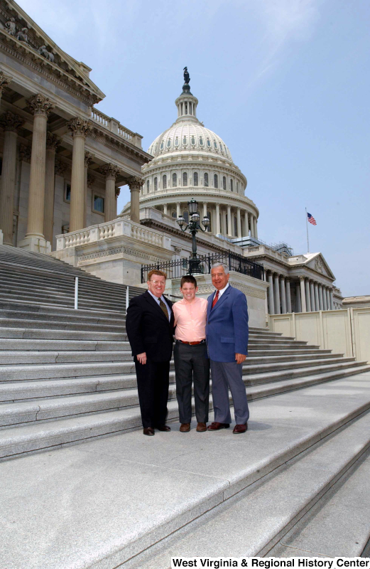 Congressman Rahall stands on the steps of the Capitol Building with a man and boy.