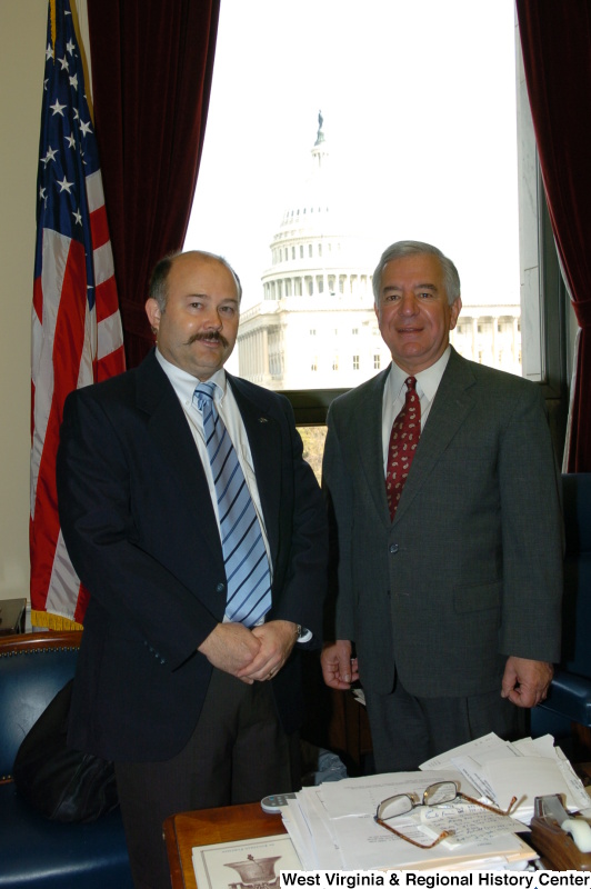 Congressman Rahall stands in his Washington office with a man wearing a blue striped tie.