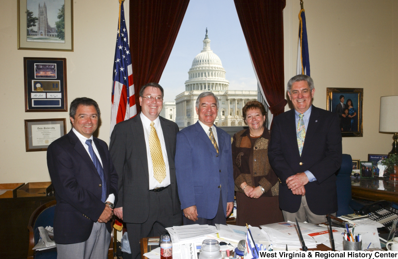 Congressman Rahall stands in his Washington office with three men and one woman.