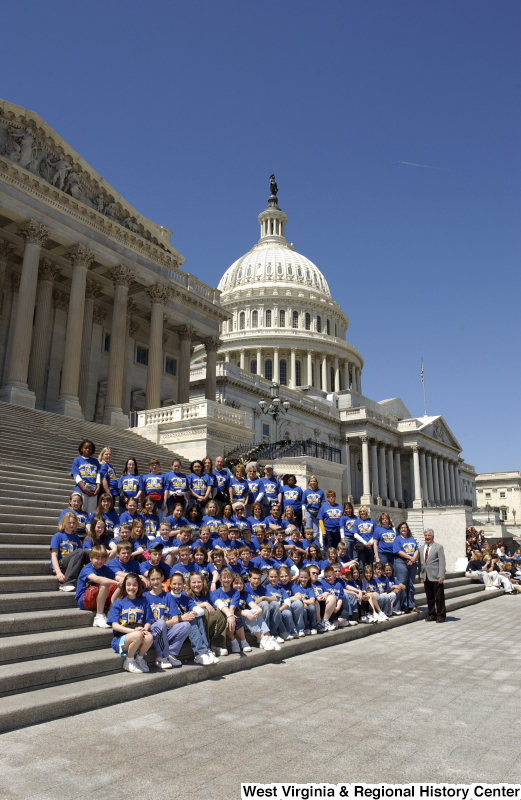 Congressman Rahall stands on the steps of the Capitol Building with children and adults wearing blue and gold shirts.