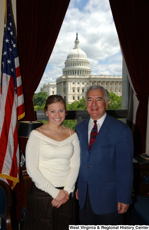 Congressman Rahall stands in his Washington office with a woman wearing a white top and brown skirt.