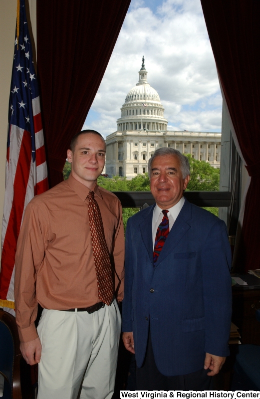 Congressman Rahall stands in his Washington office with a man wearing an orange-tinted shirt and red tie.