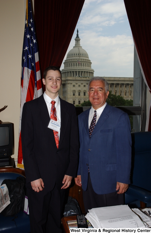 Congressman Rahall stands in his Washington office with a young man wearing a NYLC badge.