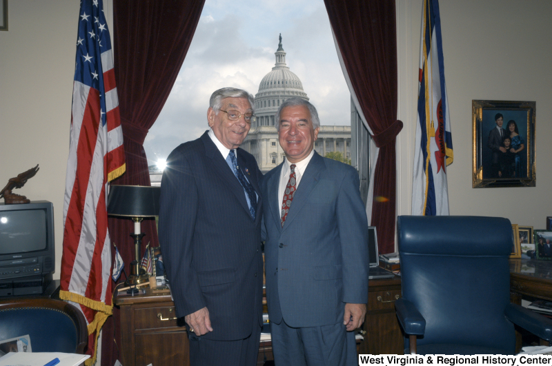 Congressman Rahall stands in his Washington office with a man wearing a dark blue pinstripe suit.