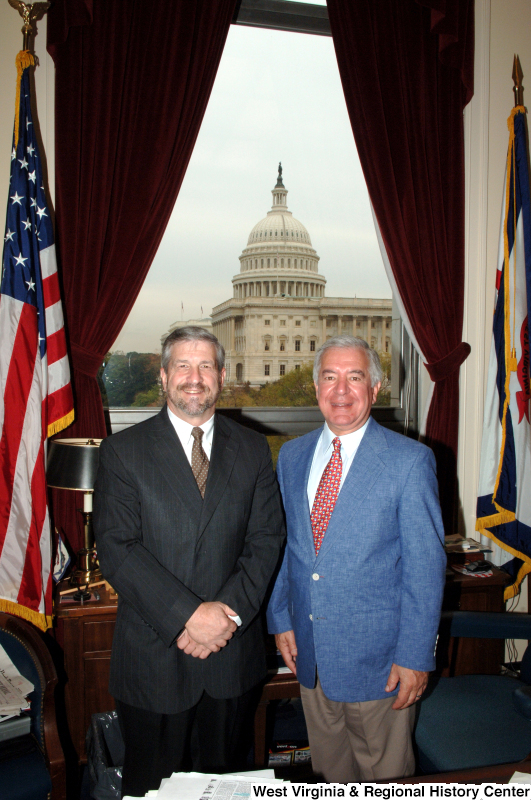 Congressman Rahall stands in his Washington office with a man wearing a dark suit and brown spotted tie.