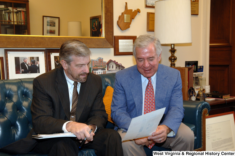 Congressman Rahall sits in his Washington office with a man wearing a dark suit and brown spotted tie.