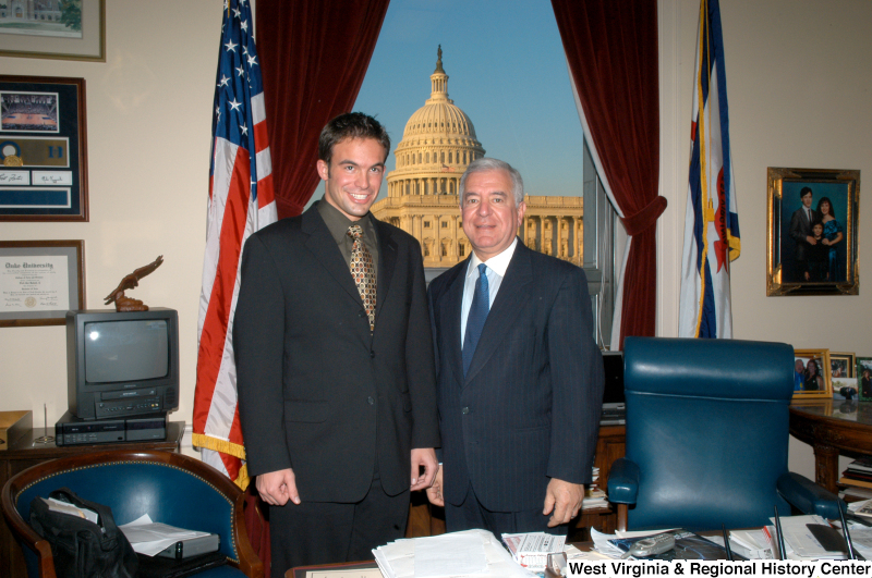 Congressman Rahall stands in his Washington office with a man wearing a dark suit and multicolored tie.
