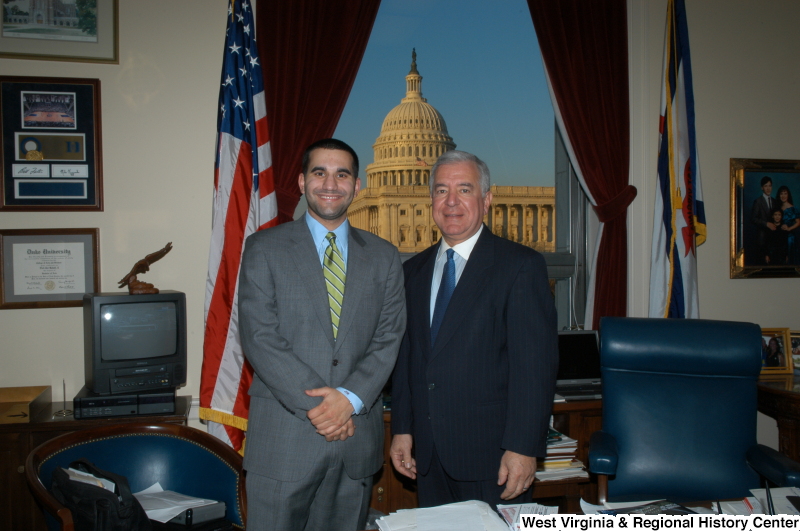 Congressman Rahall stands in his Washington office with a man wearing a grey suit, blue shirt, and green striped tie.