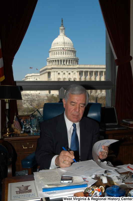 Congressman Rahall signs papers at his desk in his Washington office.