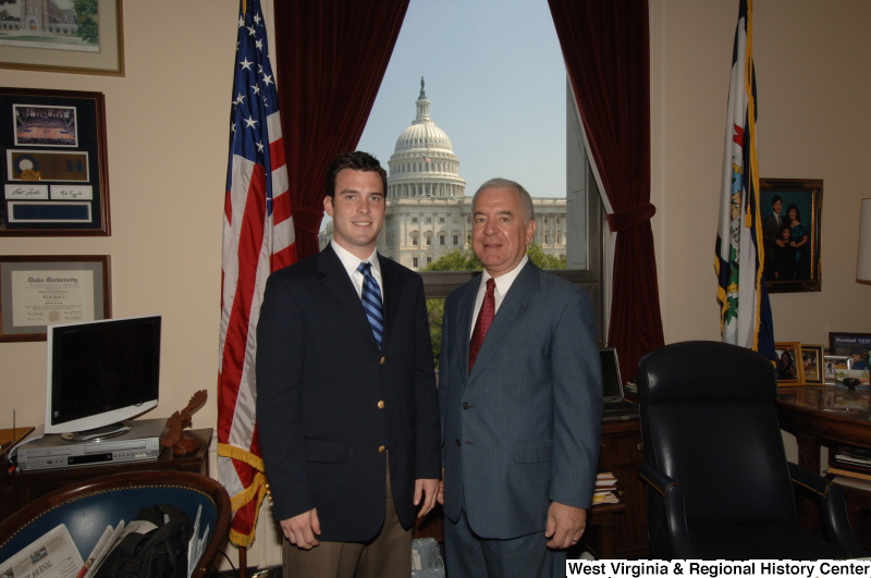 Congressman Rahall stands in his Washington office with a man wearing a dark blazer and blue striped tie.