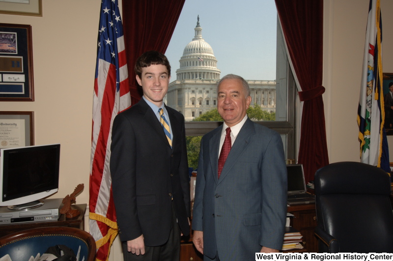 Congressman Rahall stands in his Washington office with a man wearing a dark suit and blue and gold striped tie.