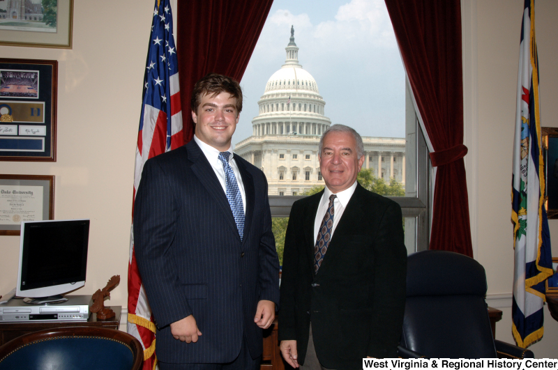 Photograph of Congressman Rahall in his Washington office standing with a man wearing a dark pinstripe suit and blue tie