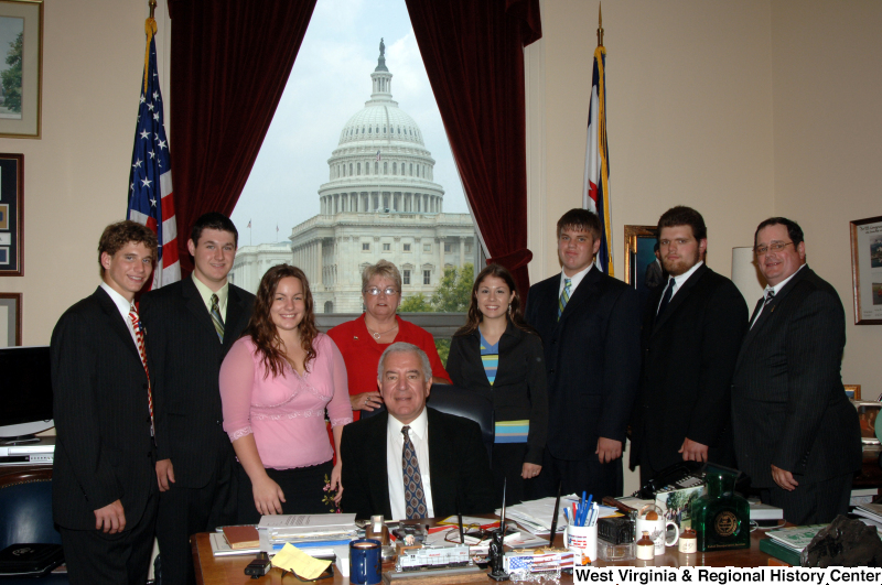 Congressman Rahall sits in his Washington office with a group of five men and three women.