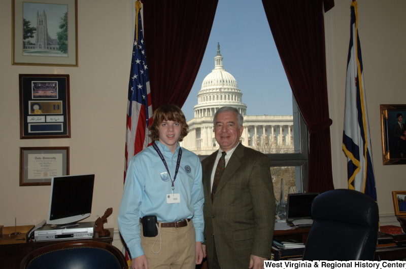 Congressman Rahall stands in his Washington office with a young man wearing a People To People Ambassador Programs lanyard.