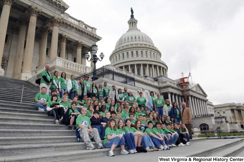 Congressman Rahall stands on the steps of the Capitol Building with children and adults wearing green Bradley Elementary shirts.