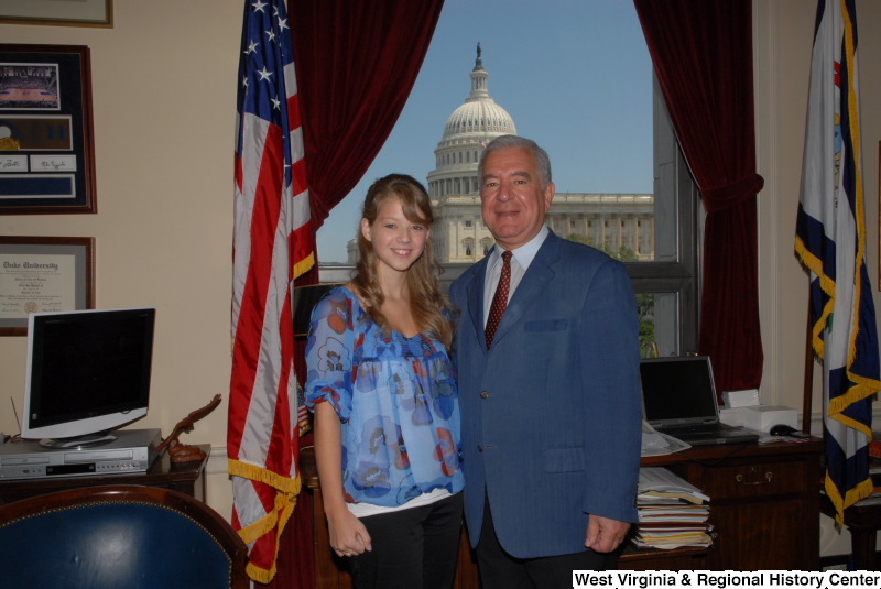 Congressman Rahall stands in his Washington office with a woman wearing a blue and red blouse.