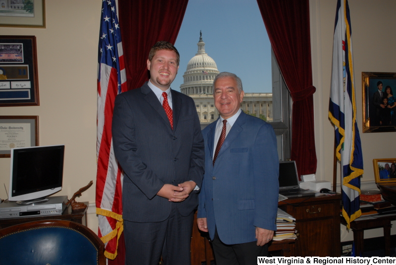 Congressman Rahall stands in his Washington office with a man wearing a dark blue pinstripe suit and red tie.