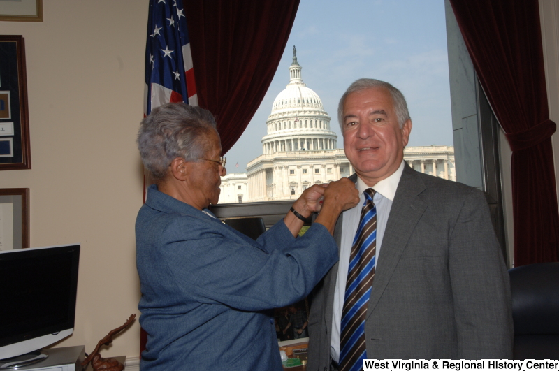 Photograph of Congressman Rahall standing in his Washington office with a representative of the Divided We Fail Movement