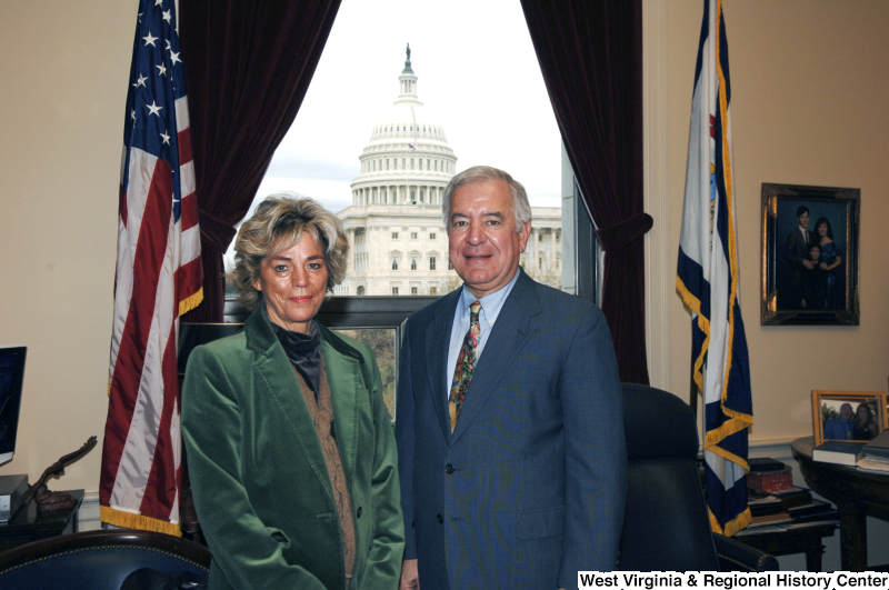 Congressman Rahall stands in his Washington office with a woman wearing a green jacket.
