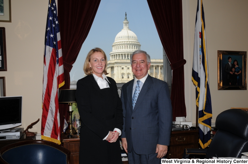 Congressman Rahall stands in his Washington office with a woman wearing a black suit and white shirt.