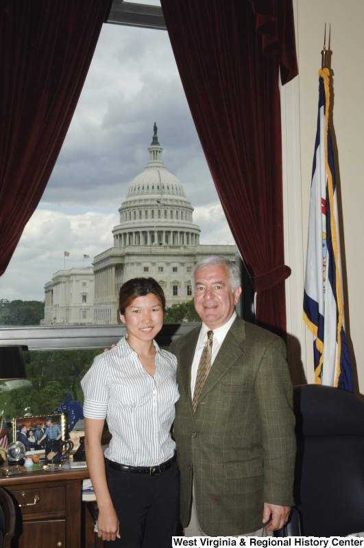 Congressman Rahall stands in his Washington office with a woman wearing a striped short-sleeve shirt.