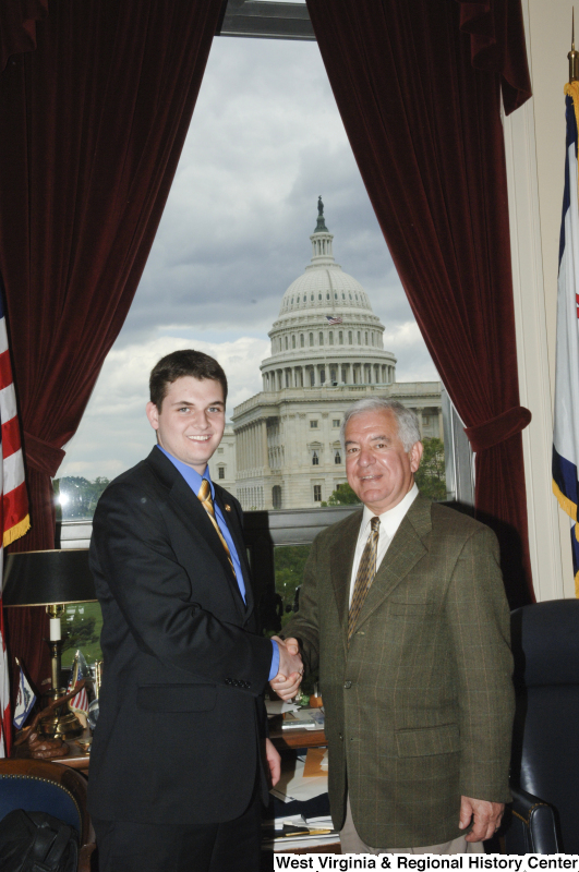 Congressman Rahall in his Washington office shakes hands with a man wearing a dark suit and light blue shirt.