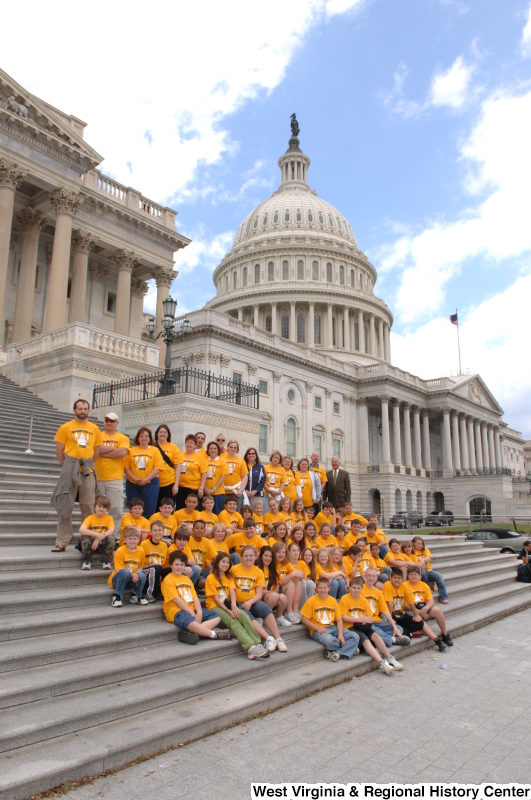 Congressman Rahall stands on the steps of the Capitol Building with children and adults wearing orange shirts.