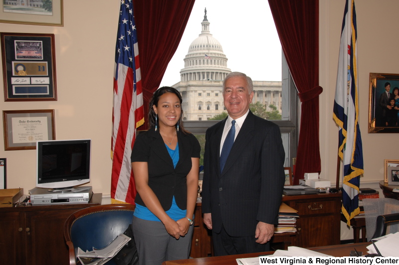 Congressman Rahall stands in his Washington office with a woman wearing a blue shirt and black short-sleeved jacket.